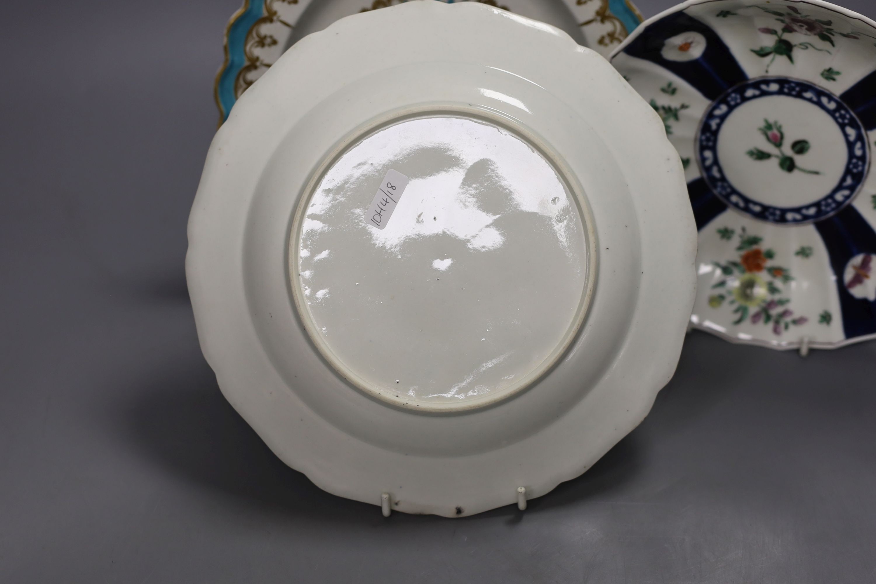 A Worcester plate with two turquoise borders, the centre painted with flowers, a saucer dish with fan shaped panels painted with flowers separated by blue panels and a claret ground plate, turquoise plate 21 cms diameter